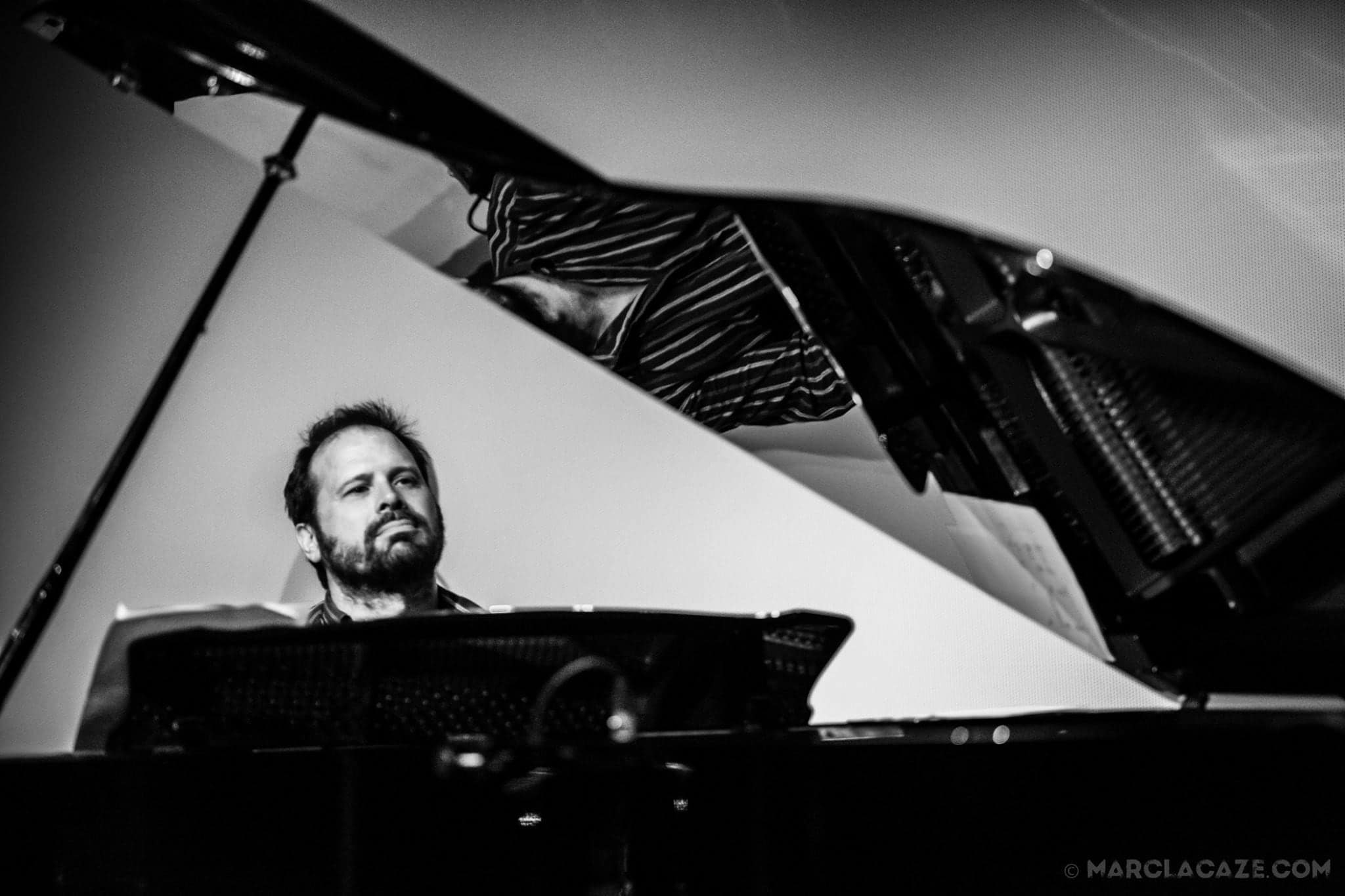 Stephen Grant at a grand piano, lid raised.